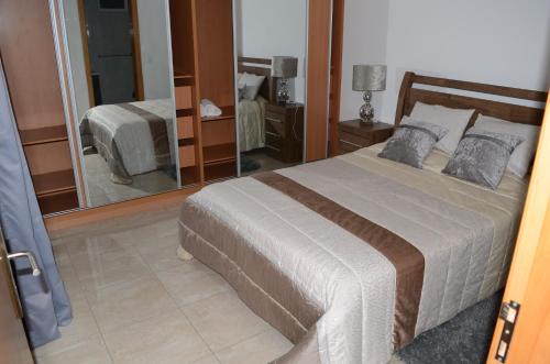 1 dormitorio con cama y espejo grande en La Terraça, en Praia