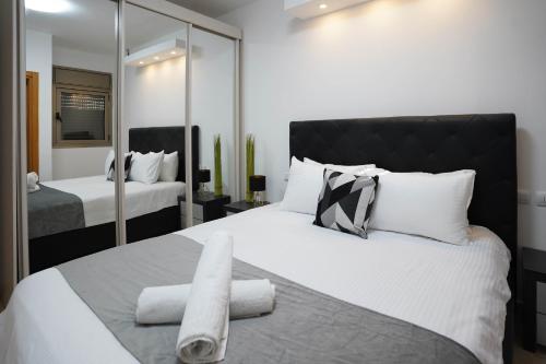 a bedroom with a large white bed with a mirror at Daniel's garden apartment in Eilat