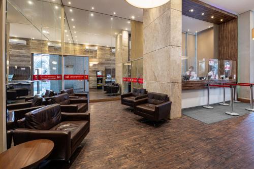a waiting room with leather chairs and a bar at S4 Hotel Águas Claras in Brasilia