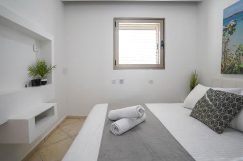a white room with a bed and a window at Daniel's garden apartment in Eilat