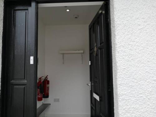 a black door in a room with a fire hydrant at Broughty Ferry Road Hotel by Pillow in Dundee