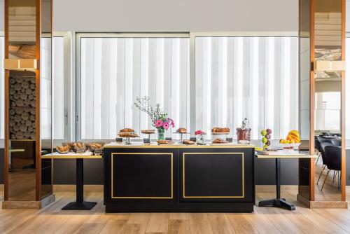 a dining room with a table with food on it at Hotel Imperiale Rimini & SPA in Rimini
