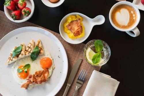 a table with plates of food and a cup of coffee at Hotel Imperiale Rimini & SPA in Rimini