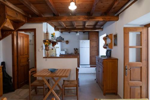 a kitchen with wooden ceilings and a wooden table at Stone House in Lafkos Pelion in Lafkos