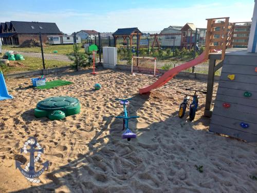 a playground in the sand with a slide at Morska Enklawa in Gąski