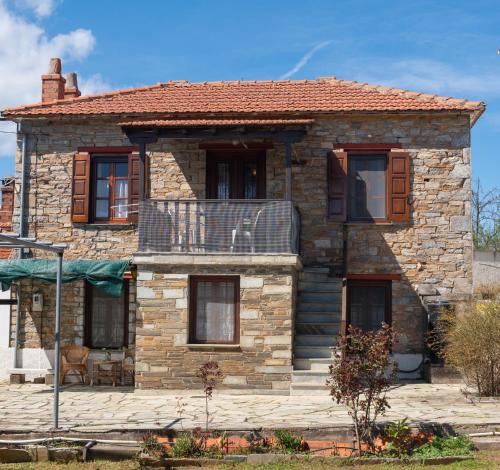 a stone house with a balcony in front of it at Stone House in Lafkos Pelion in Lafkos