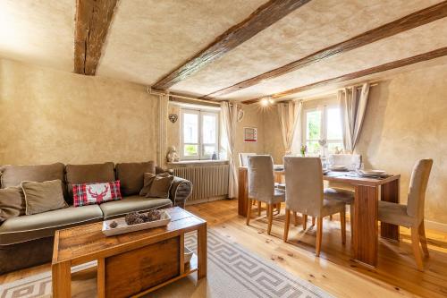 un salon avec un canapé et une table dans l'établissement La maison d'Amélie, à Birkenwald