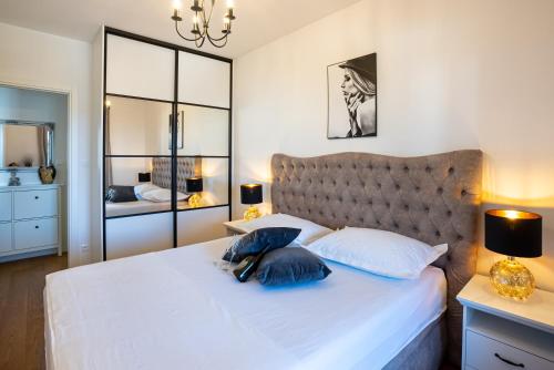 a bedroom with a large white bed with blue pillows at Morska vila 6 Luxury Apartment Žnjan in Split