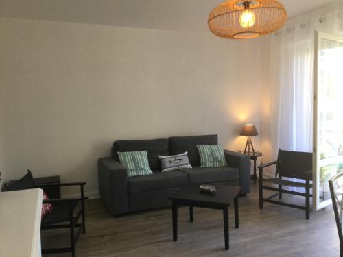 a living room with a couch and a table at Le Parc plein centre près de la Grande plage in Carnac