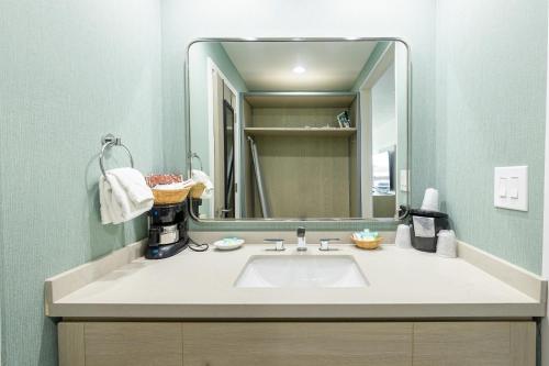 uma casa de banho com um lavatório e um espelho grande em Jot's Resort em Gold Beach
