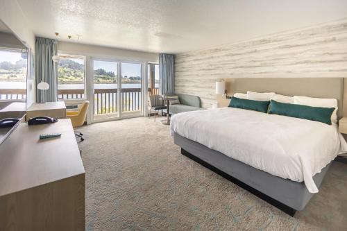 a hotel room with a large bed and a desk at Jot's Resort in Gold Beach