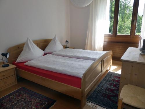 een slaapkamer met een bed met witte lakens en een raam bij Arosa Brueggli B02 in Arosa