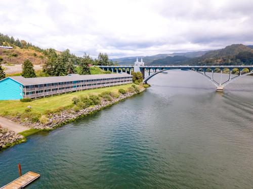 a bridge over a river with a building next to it at Jot's Resort in Gold Beach