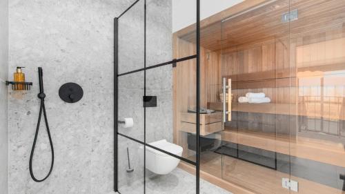 een badkamer met een glazen douche en een toilet bij Villa Curitico in Kadumi