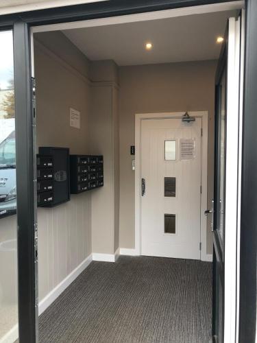 a hallway with a white door and a car parked at Broughty Ferry Road Hotel by Pillow in Dundee