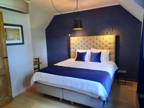 a bedroom with a large bed with a blue wall at B&B Scheldekant in Oudenaarde