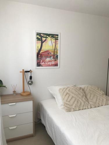 a bedroom with a bed and a picture on the wall at Mon littoral ( rez-de-jardin ) 100 m de la plage in Le Pradet