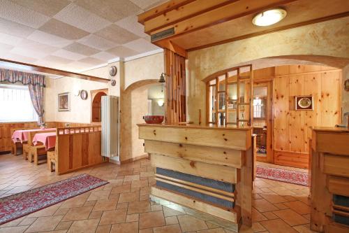 a kitchen and dining room in a home with wooden walls at Hotel Stella Alpina in Fai della Paganella