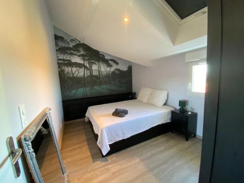 1 dormitorio con 1 cama y una pintura en la pared en Appart & Fleurinoise balcon ascenseur climatisation, en Fleurieux-sur-lʼArbresle