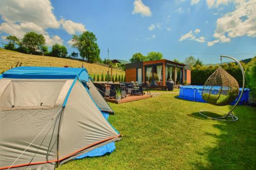 namiot i huśtawka w ogrodzie z domem w obiekcie Osada Kotarz w Brennie