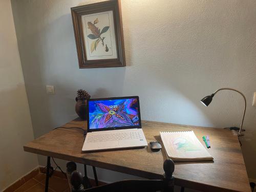 a laptop computer sitting on top of a wooden table at Casa Artista in Pedro Bernardo