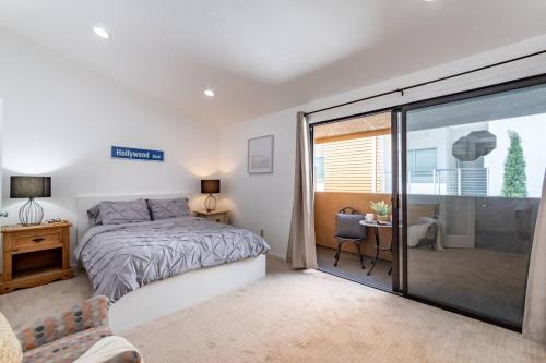 a bedroom with a bed and a sliding glass door at Franklin Loft Walk to Hollywood Bowl in Los Angeles