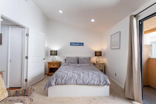 a white bedroom with a bed and two night stands at Franklin Loft Walk to Hollywood Bowl in Los Angeles