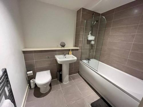 a bathroom with a sink and a toilet and a bath tub at Modern 1 Bedroom Apartment by BOLD Apartments in Liverpool