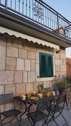 a table with fruit on it in front of a building at Apartmani Tripalo in Imotski
