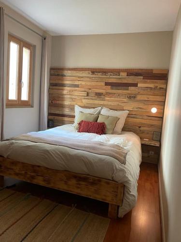 a bedroom with a large bed with a wooden headboard at Wood spirit in Avignon