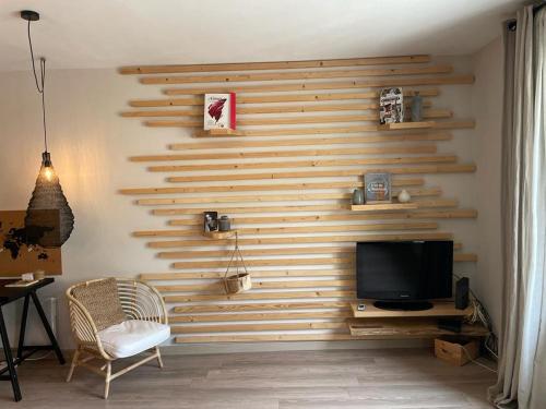 a living room with a wooden wall with a television at Wood spirit in Avignon