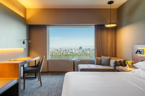a hotel room with a bed and a desk and a window at Hyatt Regency Mexico City in Mexico City