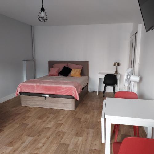 - une chambre avec un lit avec des draps roses et une table dans l'établissement 2 LYS Orleans Downtown, free secure parking, à Orléans