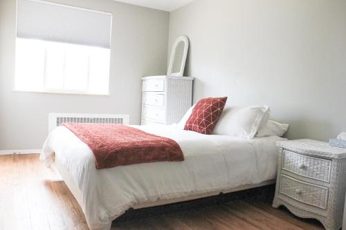 a bedroom with a bed with a red blanket and a window at The Abbey in Leadville