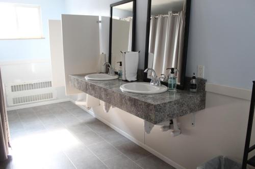 a bathroom with two sinks and a large mirror at The Abbey in Leadville