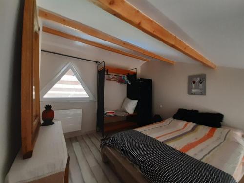 une chambre mansardée avec un lit et une fenêtre dans l'établissement appartement indépendant à 10min des plages au calme proche O'gliss et O'funparken campagne, à La Jonchère