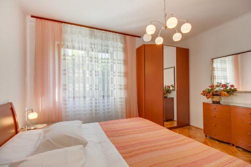 a bedroom with a large bed and a window at Apartman Mirjana 1 in Mali Lošinj
