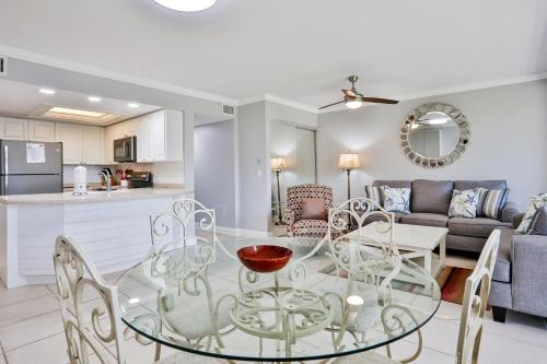 a kitchen and living room with a glass table and chairs at Midnight Cove II 823 in Siesta Key