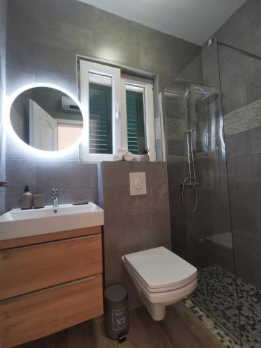 a bathroom with a toilet and a sink and a shower at Apartmani Tripalo in Imotski