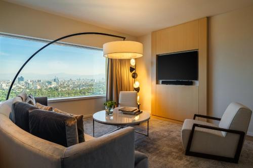 a living room with a couch and a table and a large window at Hyatt Regency Mexico City in Mexico City