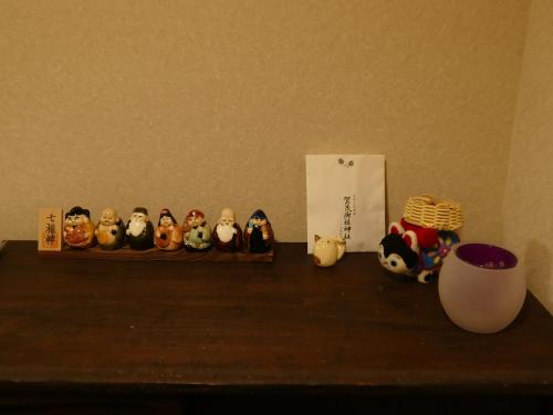 a shelf with a group of figurines on a table at 東山の宿 藤屋 in Gionmachi