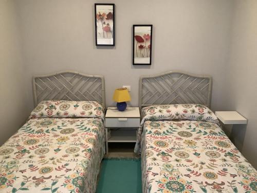 2 camas en una habitación con escritorio y 2 camas en Apartamentos Costamar en Arona