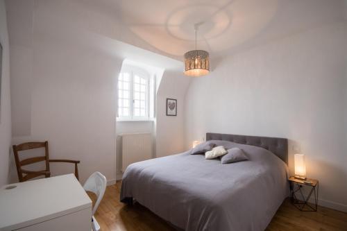 - une chambre avec un lit, une table et une lampe dans l'établissement Appartement 4 chambres vue mer Intra-Muros, parking inclus, à Saint-Malo