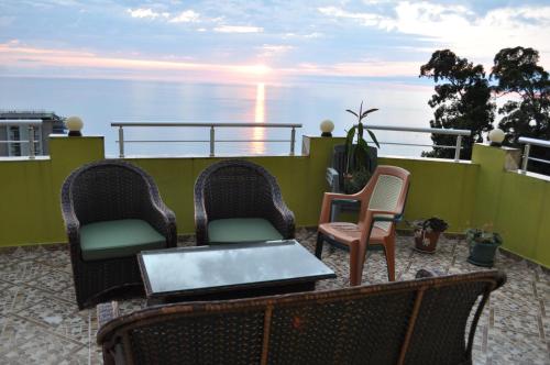 a balcony with two chairs and a table with a laptop at Akhmed Guest House in Kvariati