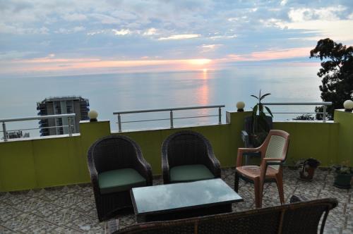 a balcony with chairs and a table and the ocean at Akhmed Guest House in Kvariati