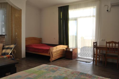 1 dormitorio con 1 cama y una ventana con en Akhmed Guest House, en Kvariati