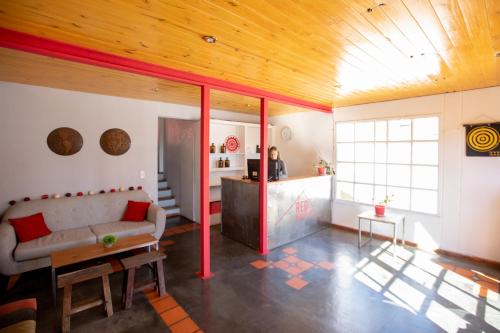 een woonkamer met een bank en een tafel bij Red House Hostel in El Calafate