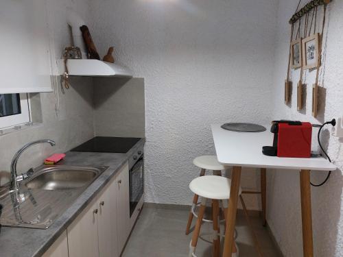 een kleine keuken met een wastafel en een tafel bij Vitamin Sea house in Panayía