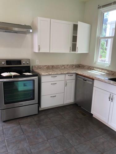 a kitchen with white cabinets and a stove top oven at 1/F 2 bed rooms in Pittsburgh
