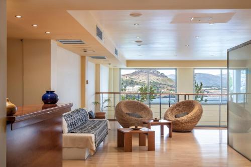 a living room with two chairs and a couch at Lindos Mare, Seaside Hotel in Líndos